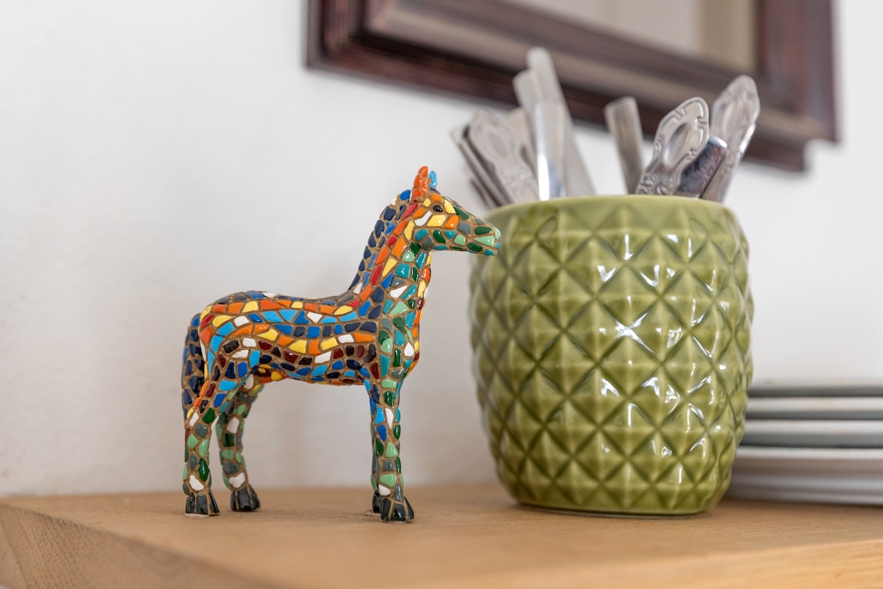 Colorful mosaic horse figurine on kitchen counter with green ceramic container