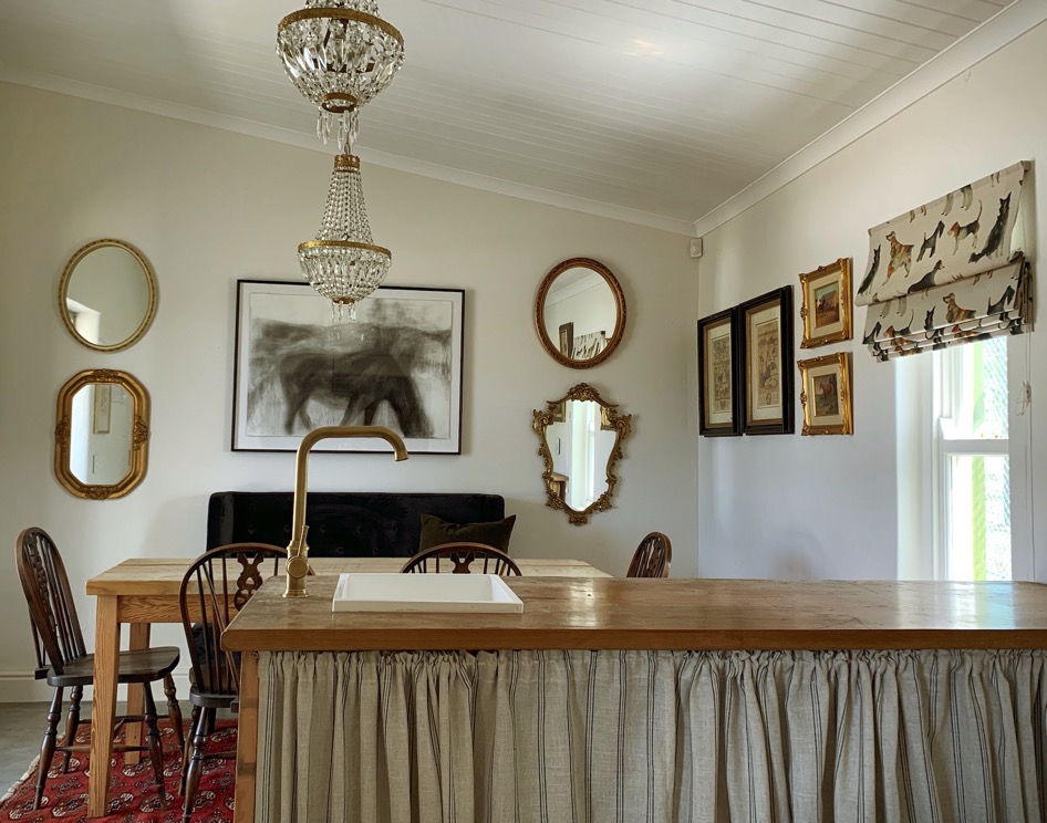 Beautifully decorated tea and tack room with crystal chandelier, antique mirrors, and equestrian artwork